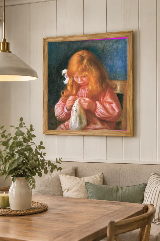 Framed print of Jean Renoir sewing hanging on a wall in a furnished room