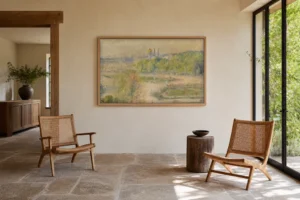 Framed print of The Tuileries Garden hanging on a wall in a furnished room