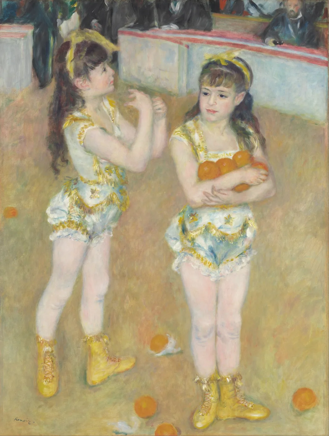 Two young circus acrobats in white and gold costumes and yellow boots holding oranges in a ring, watched by a seated audience