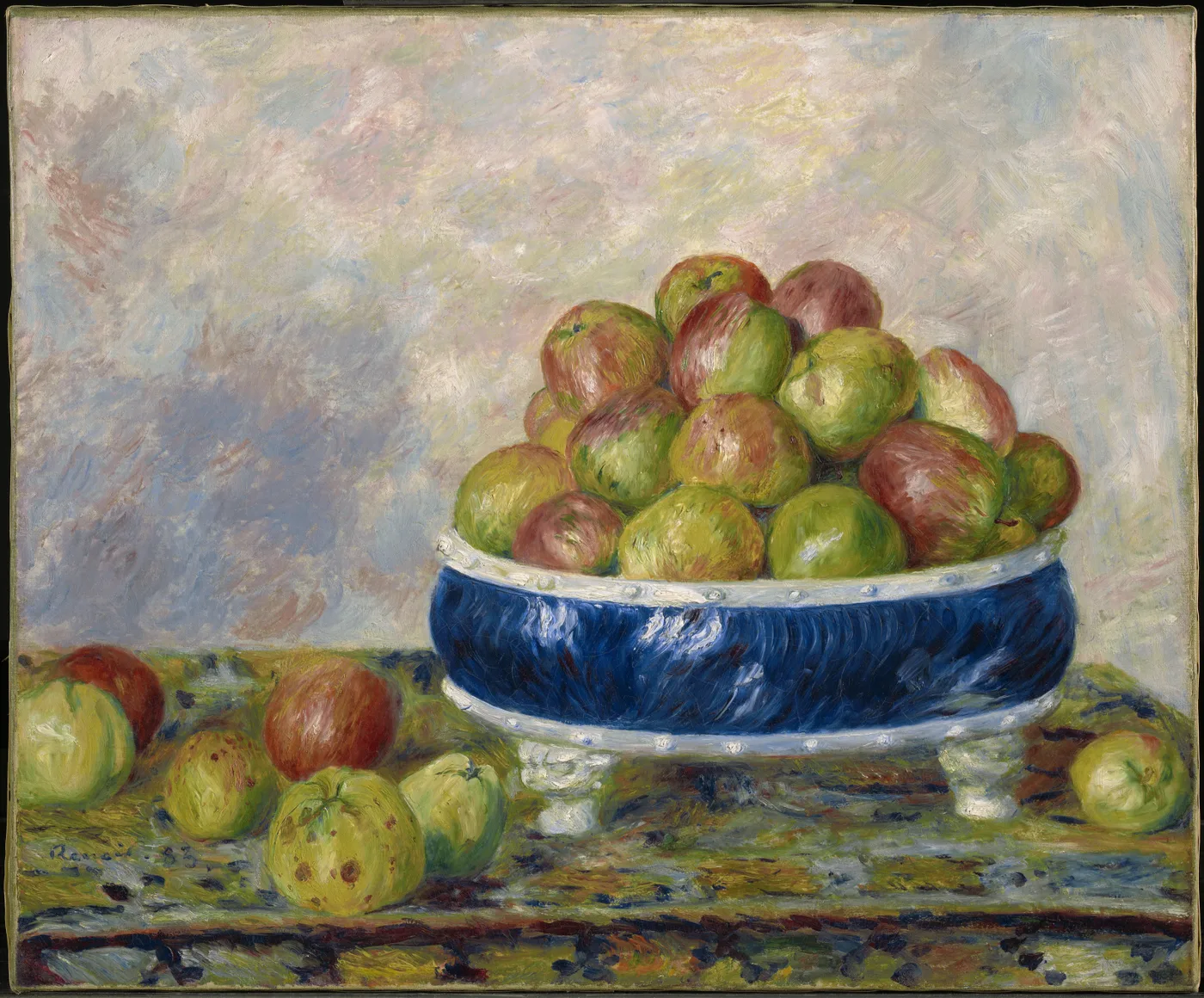 A blue and white footed bowl overflowing with green and red apples, more apples scattered on the table beside it