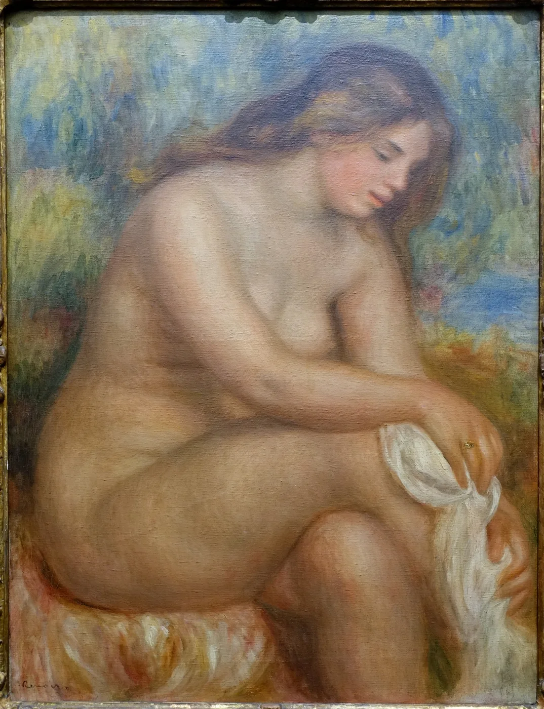 A nude bather seated outdoors, bending forward to dry her raised right leg with a white cloth, in soft flesh tones and pale blue background