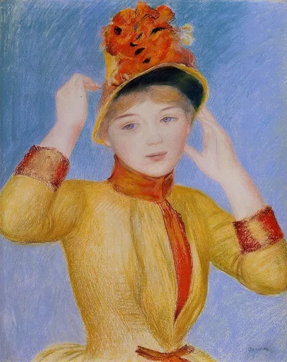 A young woman in a yellow dress with red cuffs adjusting a flower-trimmed hat with both hands, against a light blue background