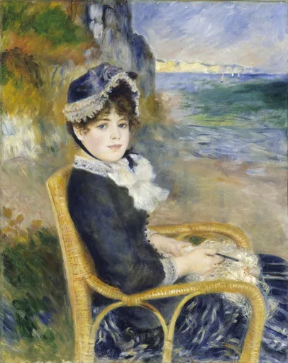 A woman in a dark blue jacket and lace-trimmed bonnet sitting in a wicker chair by the seashore, in navy blue, sandy beige, and sea green