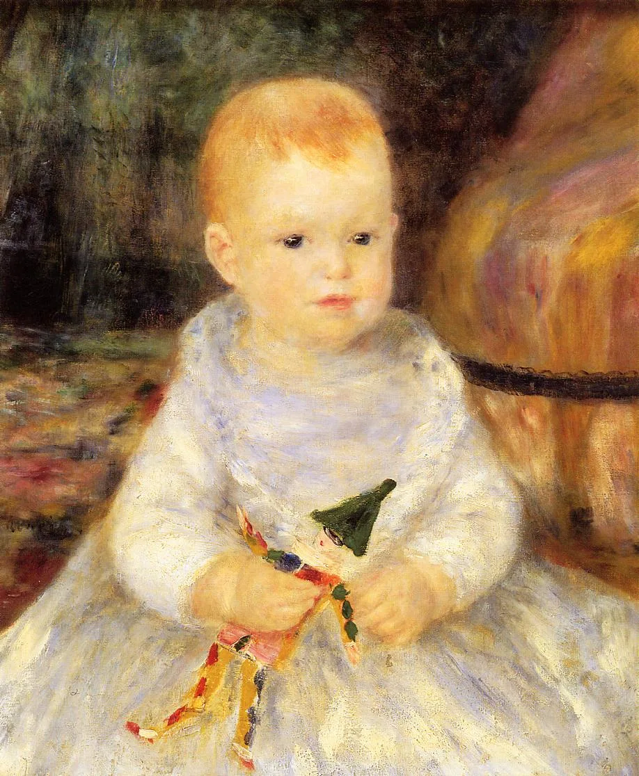 A toddler in a white dress holding a small jester puppet doll, seated indoors, in cream, orange and dark green