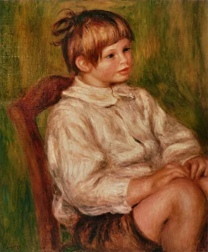 A young boy in a white shirt seated in a wooden chair with his knee raised, against a green background