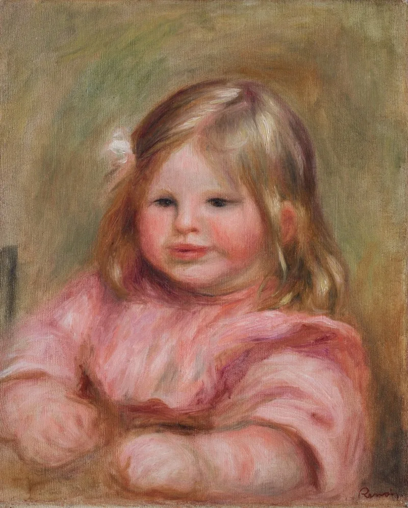 A close portrait of a round faced child in pink with a white hair bow, against an olive background