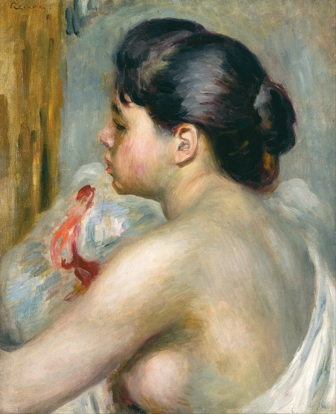 A dark haired woman seen from behind with bare shoulders holding a white cloth, against a blue-grey background