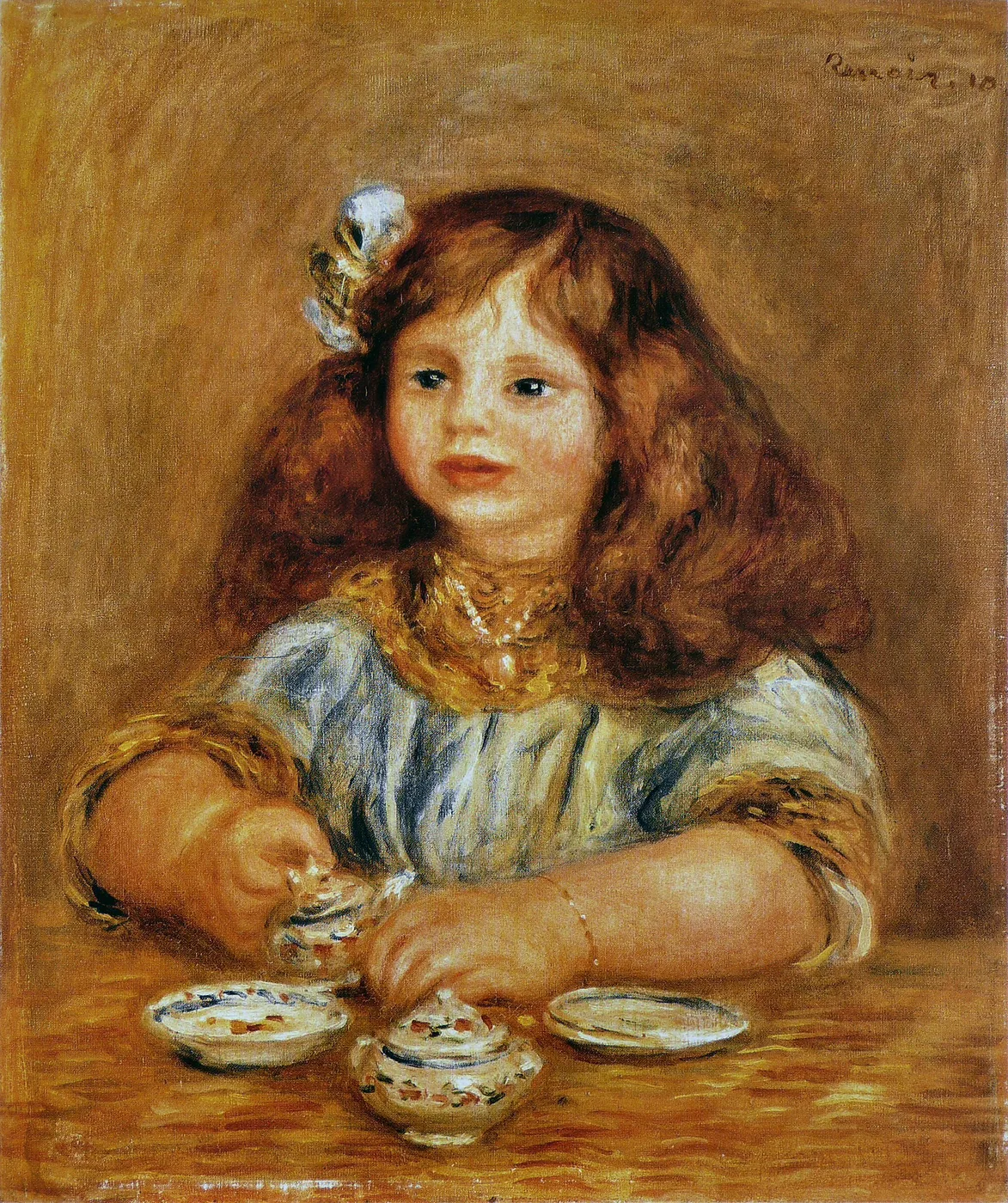 A young girl with long auburn hair and a gold necklace playing with small porcelain dishes on a table, in warm amber tones