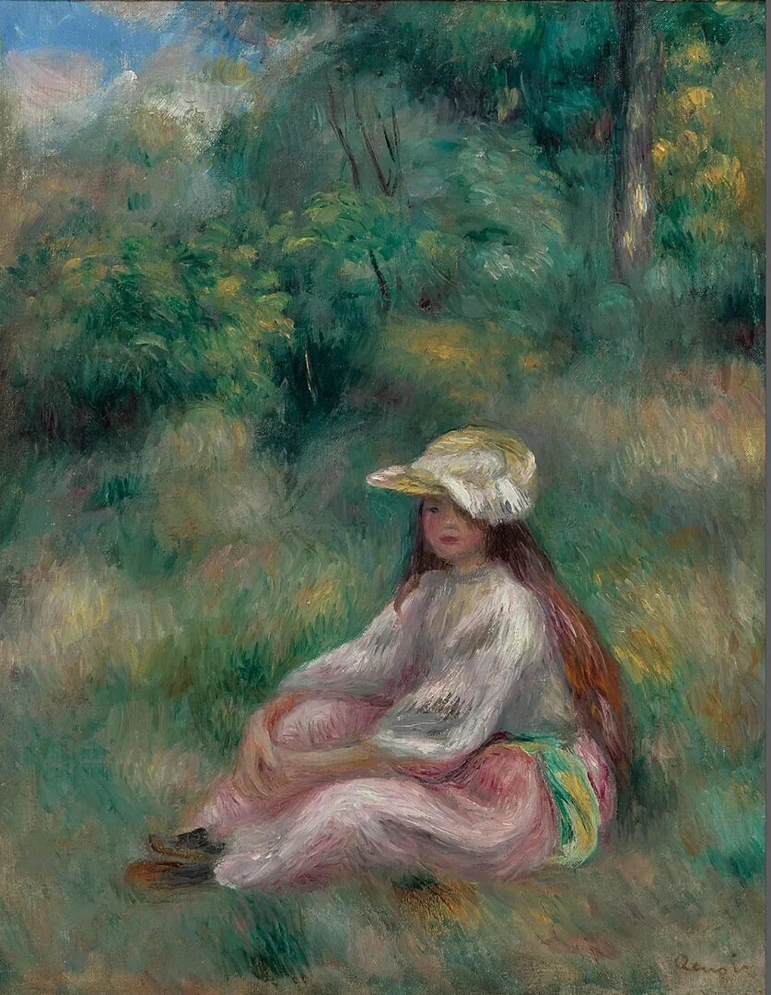 A girl in a straw hat and pink skirt with a white top sits in a lush green landscape, her long hair loose.