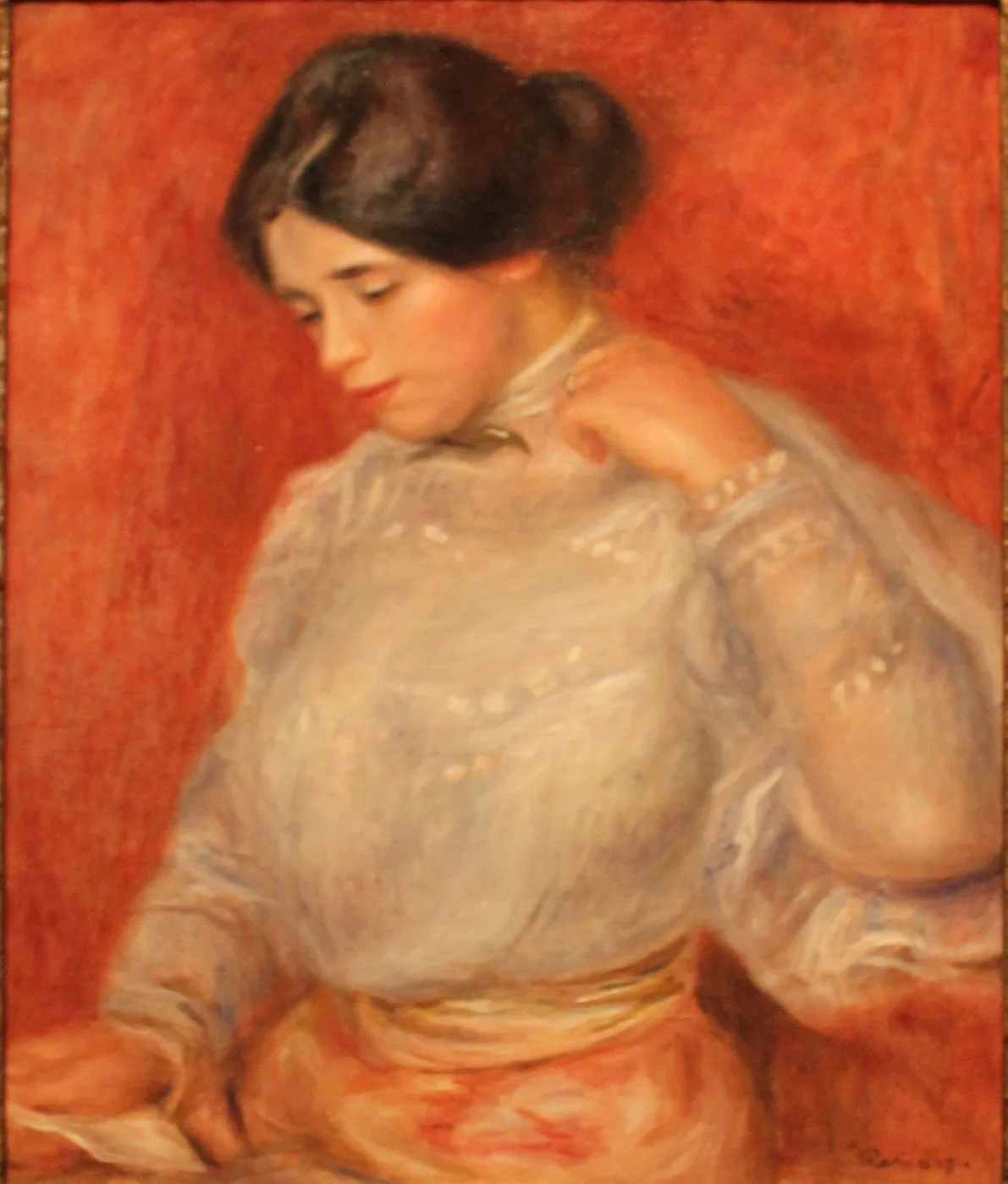 A young woman in a white lace blouse looking downward with one hand raised to her neck, against a vivid red background
