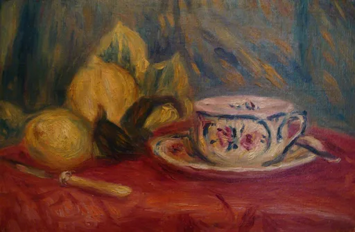 Lemons with green leaves sit beside a rose-patterned teacup and saucer on a deep red tablecloth.