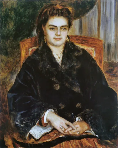 Dark-haired woman with drop earrings sits in a wooden armchair wearing a dark fur-trimmed cloak, hands folded, rings visible.