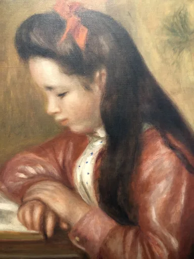 A girl with long dark hair tied by a red bow reads intently, wearing a rust-red jacket over a blue-dotted blouse.