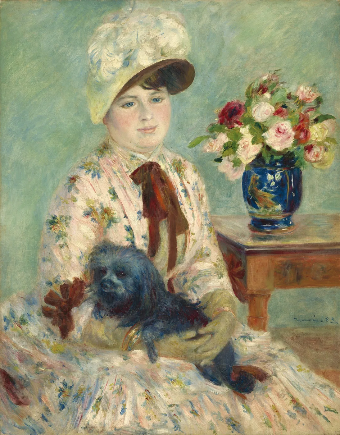 A woman in a white feathered bonnet and floral dress holds a small black dog, a vase of pink roses on the table beside her.