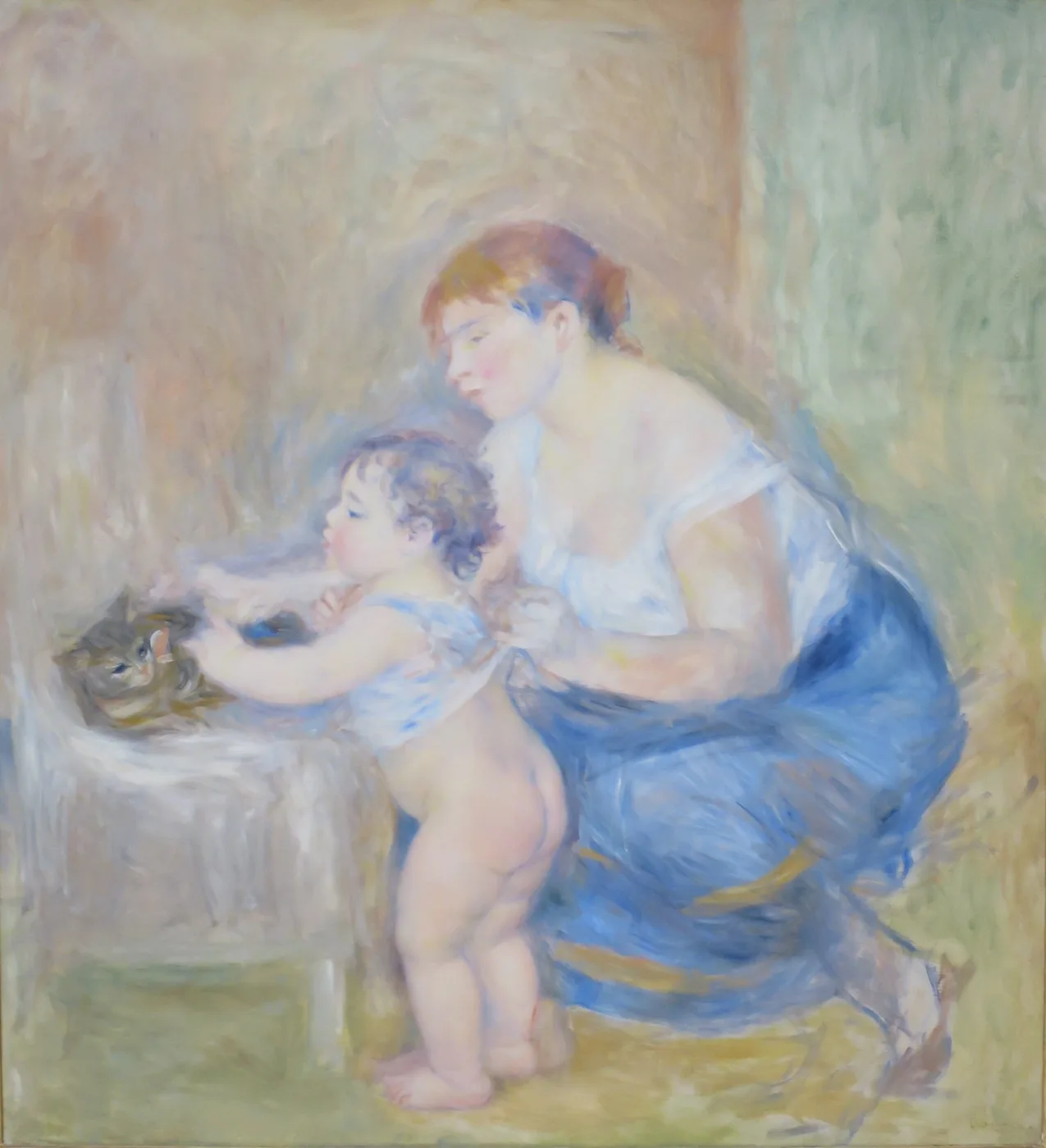 A mother in a blue skirt and white blouse holds a naked toddler standing on a table petting a small kitten, in soft pastels.