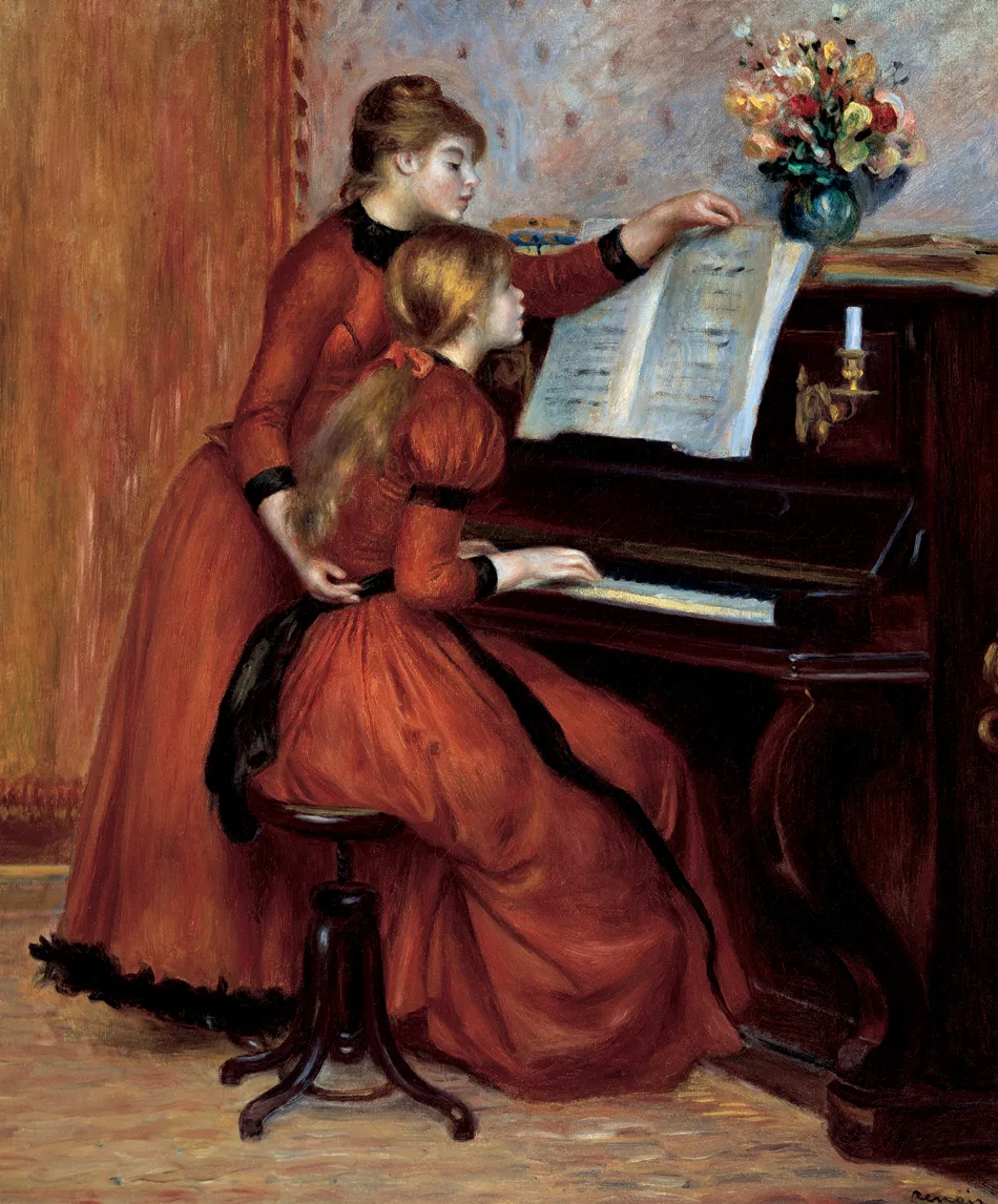 Two girls in matching red dresses at an upright piano indoors, one playing while the other turns the sheet music, flowers on top.