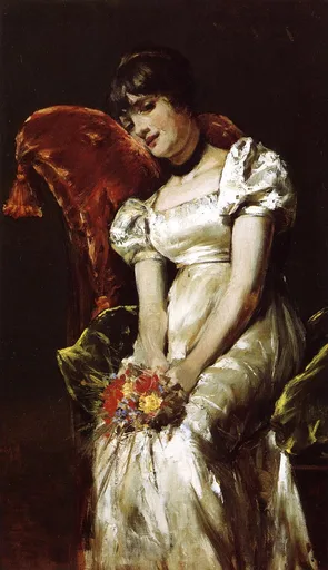 A seated young woman in a white satin dress leaning against a red velvet chair back, holding a bouquet of red and yellow flowers, against a dark background.