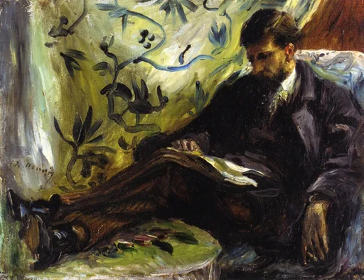 A bearded man reclining in a chair reading, legs propped up, before a yellow-green wallpaper patterned with dark foliage.