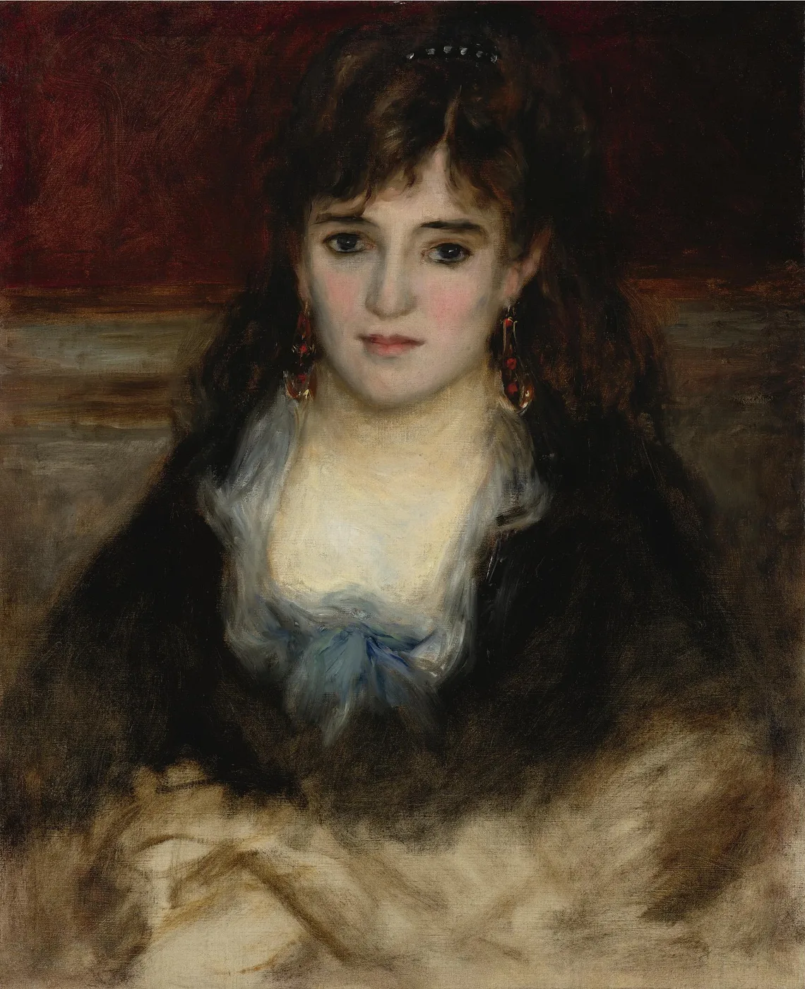 A dark-haired woman with dangling earrings gazes forward beneath a dark cloak, against a deep red and grey wall, in warm brown and red tones.