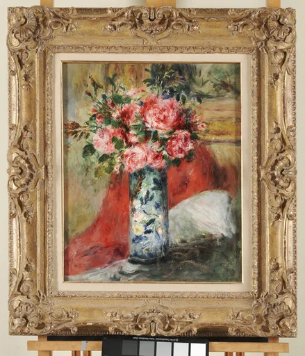 Pink roses and peonies fill a tall blue-and-white patterned vase, set against a draped red cloth, in an ornate gold frame.