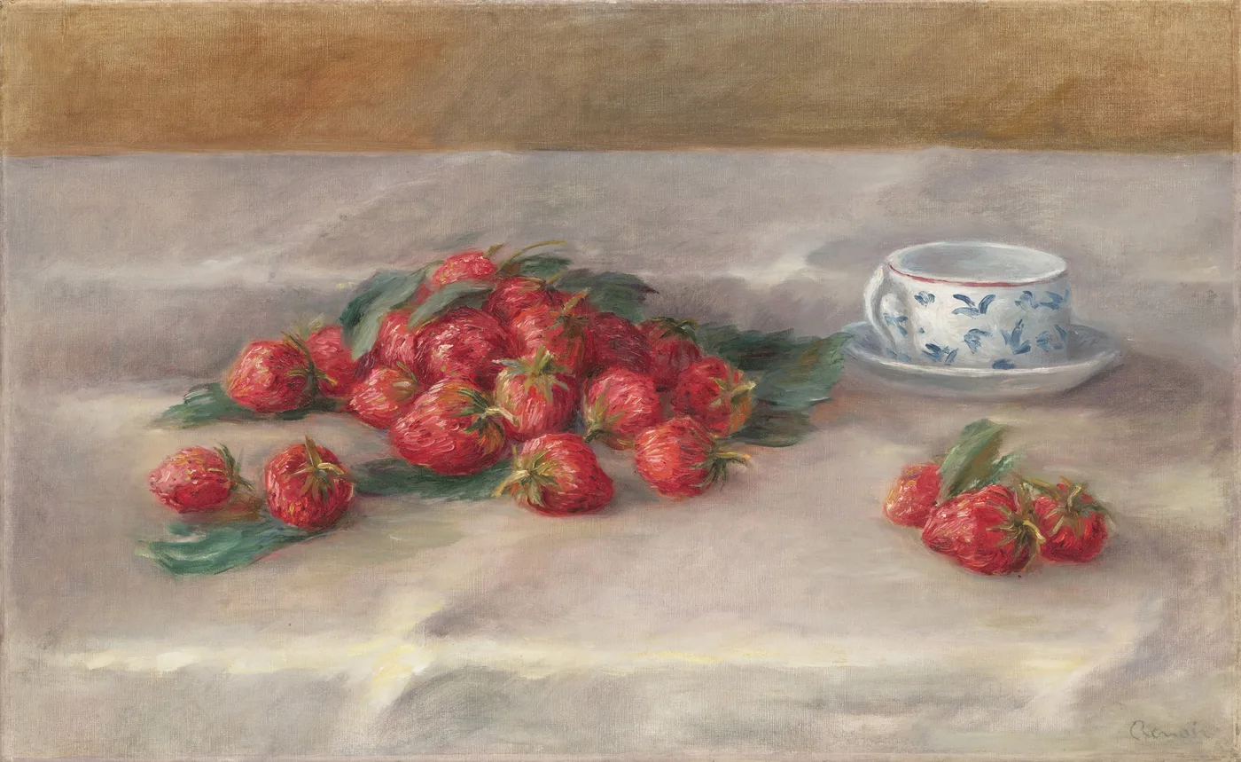 Two loose piles of ripe red strawberries with their leaves scattered on a pale cloth beside a blue-and-white patterned teacup on its saucer.