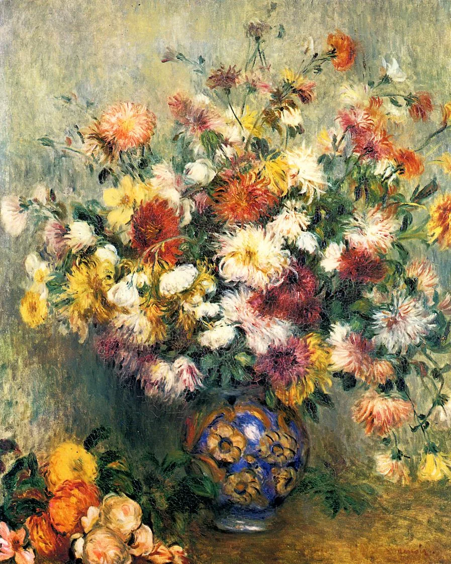 An abundant bouquet of shaggy chrysanthemums in red, yellow, and white fills a blue-and-gold patterned vase, with loose blooms piled beside it on the table.