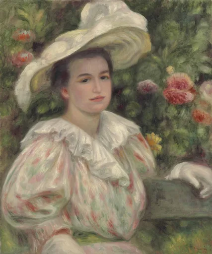 A woman in a wide white hat and ruffled floral dress seated by a rose bush, in white, pink and deep green