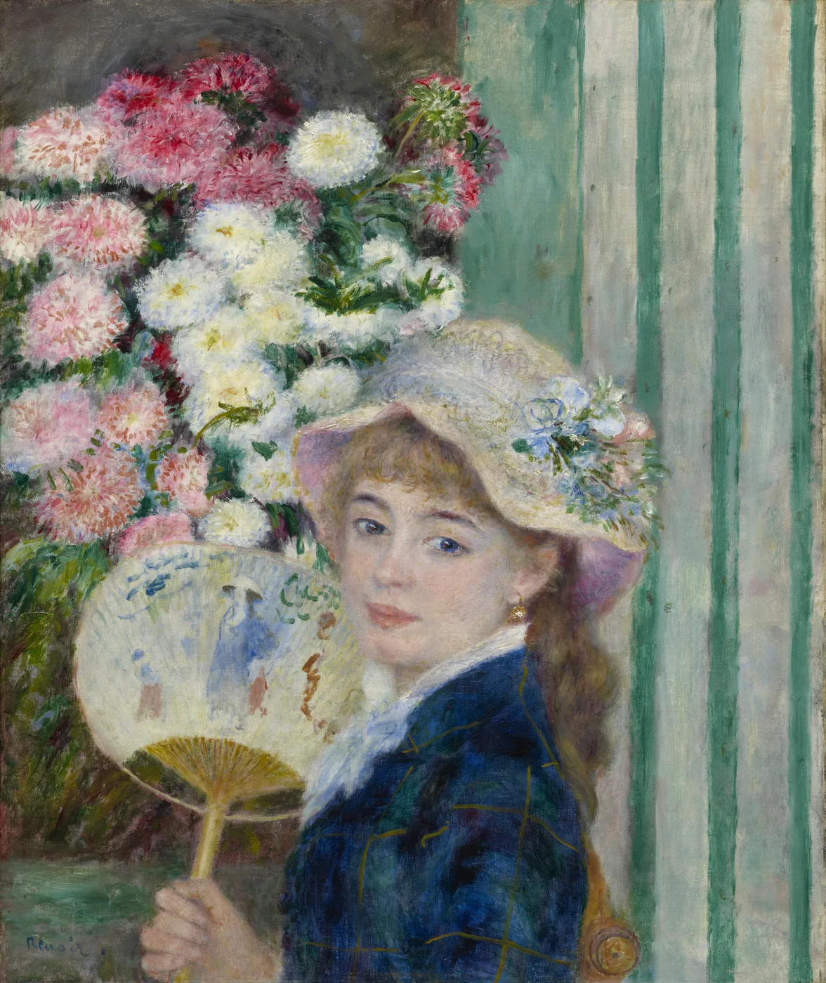 A young woman in a straw hat and dark blue jacket holds an open fan before a large bouquet of pink and white chrysanthemums